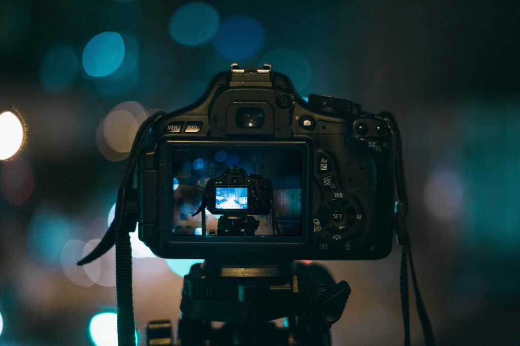 Close-up of a DSLR camera capturing a bokeh background in a dimly lit setting, illustrating night photography.
